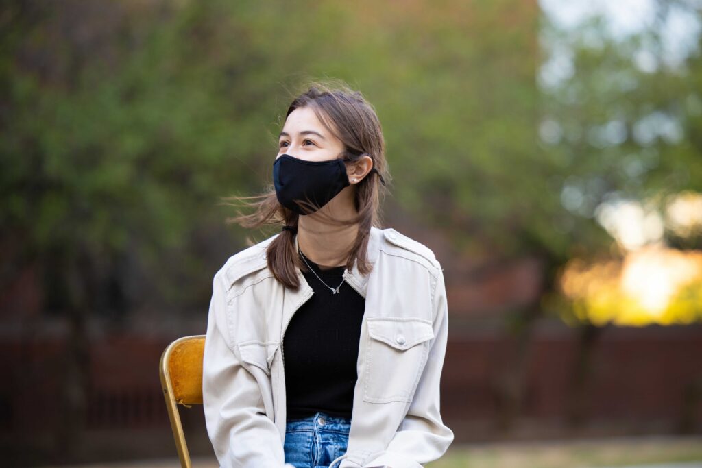 Modulate team member posing for photo outside with mask on