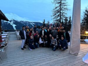 Isovalent team picture on deck with snowy mountain behind them